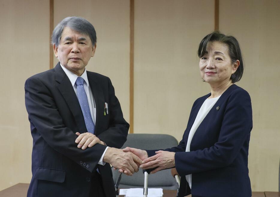 記者会見で握手する京都アニメーションの八田英明社長（左）と京都府宇治市の松村淳子市長＝1日午前、宇治市