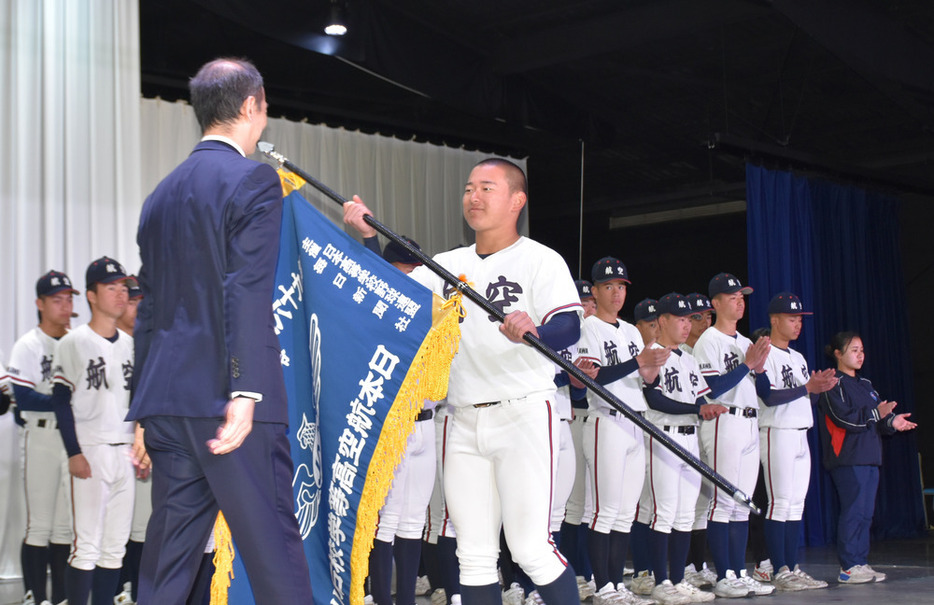 日本航空石川の青木洋介校長（手前）からセンバツ旗を渡された宝田一慧主将＝山梨県甲斐市で２０２４年３月９日、大和田香織撮影