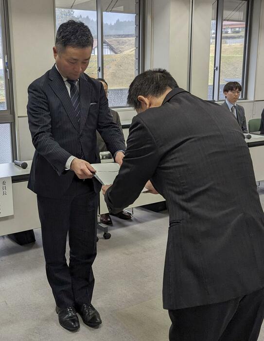 島根県邑南町役場で、石橋良治町長（右）に報告書を提出する検証委員会の委員長＝26日午後