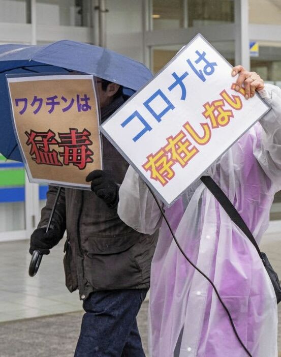 茨城県つくば市で、「コロナは存在しない」などの主張を掲げながらデモする「神真都Ｑ会」のメンバー＝２０２４年１月