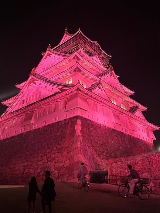 ［写真］桜色にライトアップされた大阪城。照明のそばから撮影。ピンク色がより増して見えた＝30日夜、大阪市中央区で