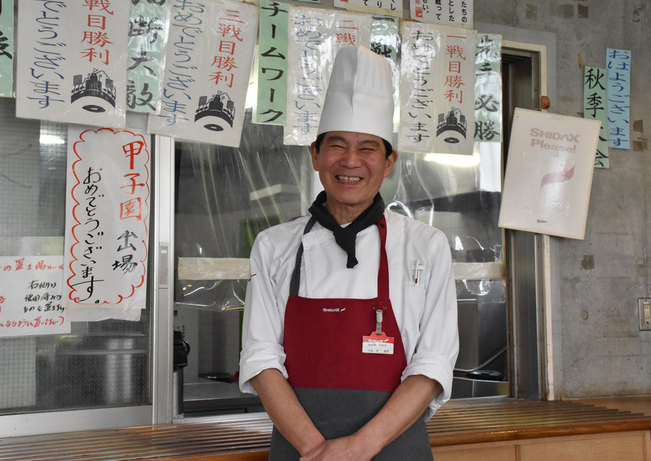 関東一野球部の食事を作っている原康浩さん。食堂には、昨秋の都大会で試合に勝つ度に書いたメッセージを貼っている＝千葉県白井市で