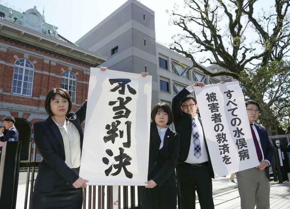 水俣病特別措置法に基づく救済策で対象外となった人たちが国などに損害賠償を求めた訴訟の熊本地裁判決で、「不当判決」を訴える原告側の弁護士ら＝22日午前、熊本市