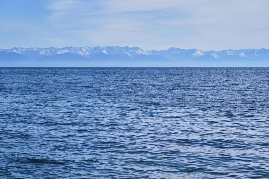 深度40mとも言われる透明度の高さのせいか、湖は深い青色に見える。バイカル湖は大陸のプレートが重なる地溝にあるため、毎年約2cmずつ幅が広がり、数ミリずつ深くなっていっているという＝リストビアンカ・バイカル湖畔にて（2018年10月撮影）