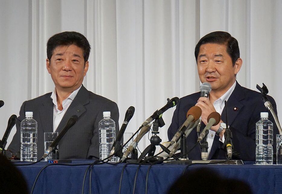 ［写真］会見で報道陣の質問にこたえる大阪維新の会の松井一郎代表（左）と公明党の佐藤茂樹府本部代表＝25日午後7時半ごろ、大阪市北区で