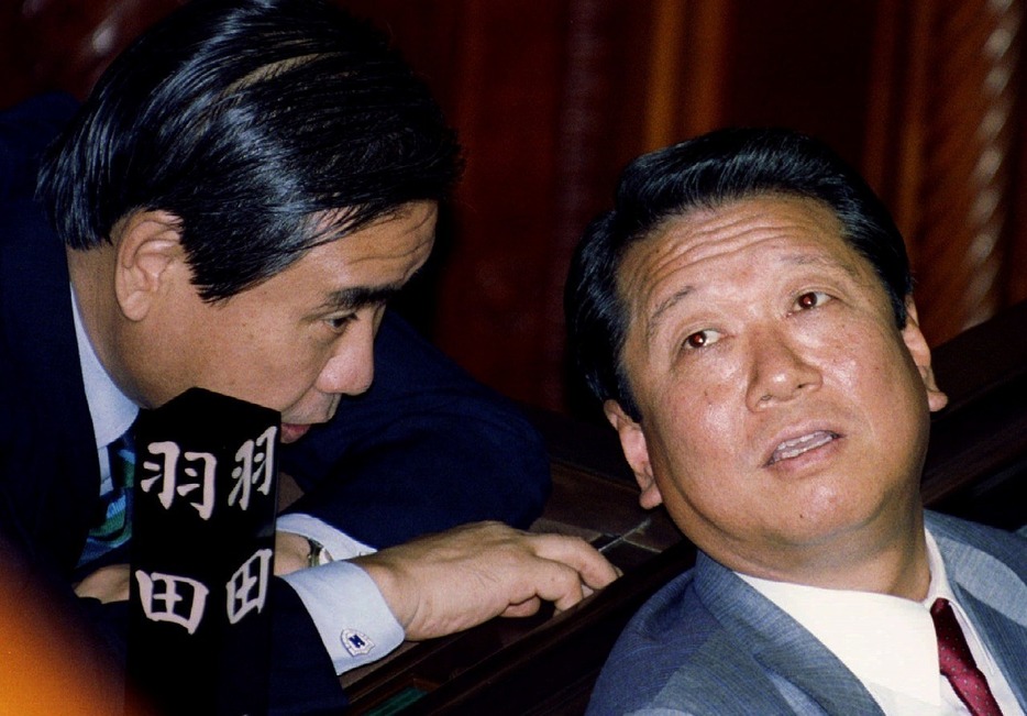 [写真]1993年8月、非自民8党派の細川政権発足の3日前の国会で、羽田孜（左）に話しかけられる小沢一郎（ロイター/アフロ）