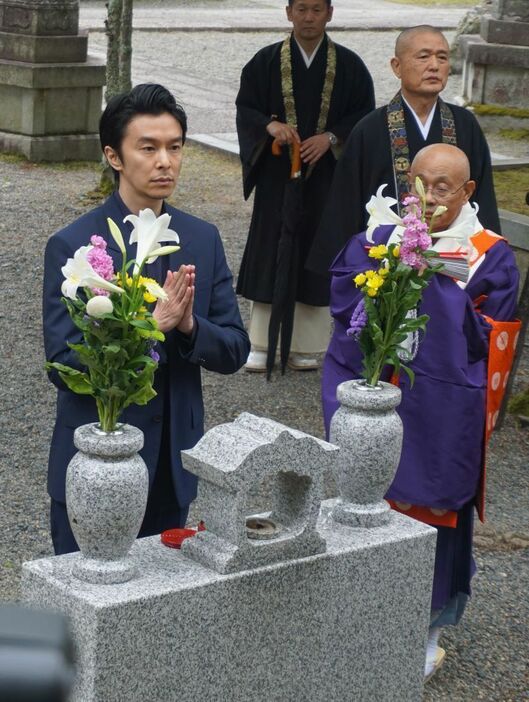 ［写真］明智一族の墓の前で手を合わせる長谷川博己＝20日午後、滋賀県大津市で