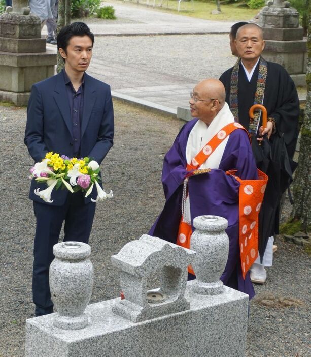 ［写真］明智一族の墓の前に立つ長谷川博己＝20日午後、滋賀県大津市で