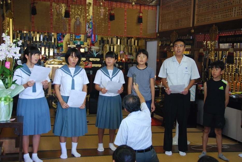 寺で行われた法要で合唱する6人＝17年7月