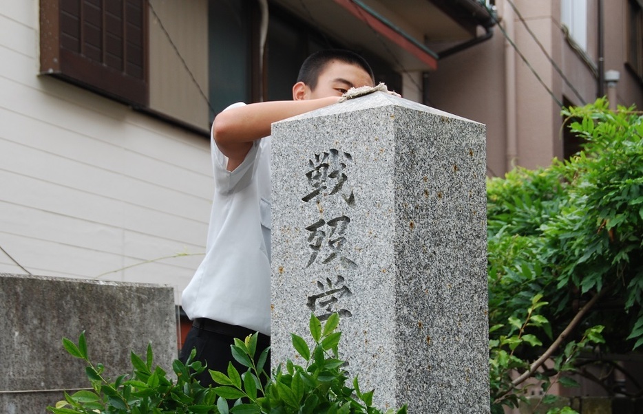 慰霊日を清掃する生徒＝17年7月