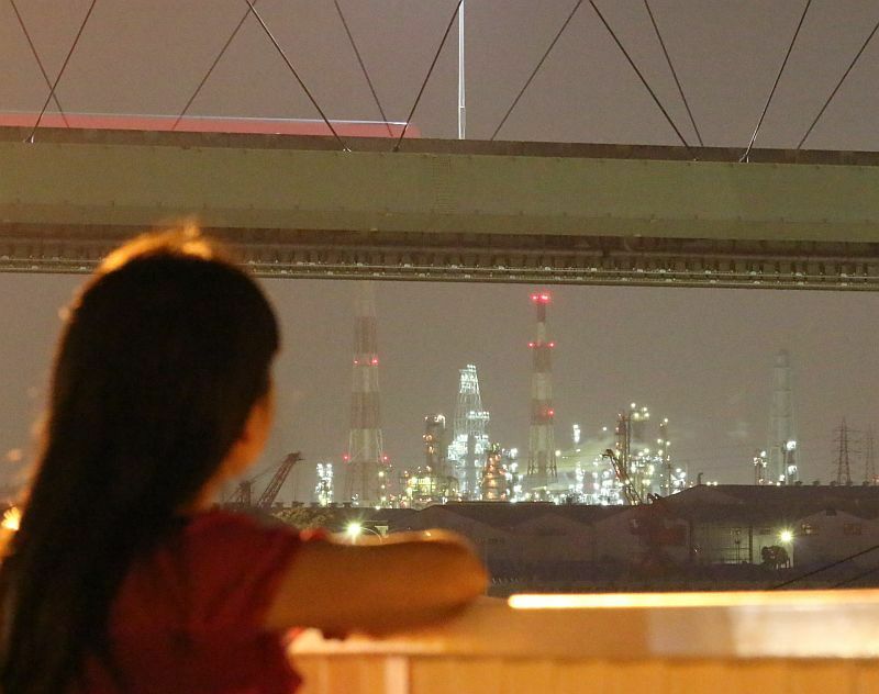 [写真]橋の向こうに見える輝きからは多くの煙もあがる。「あの場所にはなにがあるのか」と工場とわかっていても考えてしまう＝16日午後11時半ごろ、大阪府堺市で（撮影：柳曽文隆　約3秒露光）