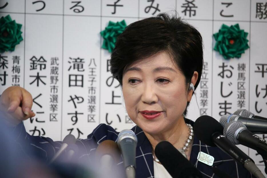 [写真]開票センターで報道各社のインタビューに答える小池氏