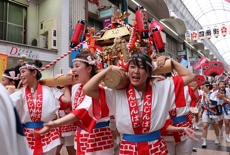 [写真]今年も元気にギャルみこしが商店街を練り歩く。「わっしょい」の声が響き周囲の人も歓声をあげる=23日午後12時5分ごろ、大阪市内で（撮影：柳曽文隆）