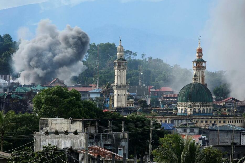 [写真]フィリピン政府軍の空爆で煙が上がるマラウィの街（ロイター/アフロ、2017年6月29日撮影）