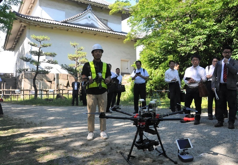 [写真]撮影に投入された大小のドローン。後ろの建物は六番櫓