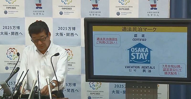[写真]大阪観光局が特区民泊の認定を受けた施設だとわかるマークを作成した。そのことを説明する大阪府の松井知事＝28日午後、大阪府庁で