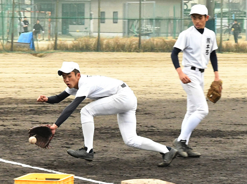 守備練習で三塁線への打球に腕を伸ばす熊本西の野田侑選手（左）＝熊本市西区の熊本西高校で、清水晃平撮影
