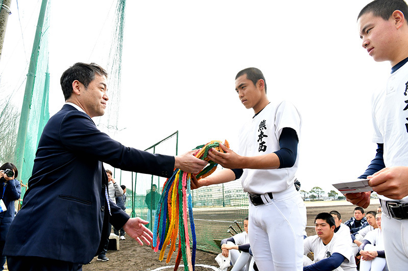 熊本西の堺祐太選手（中央）に千羽鶴を託す野球部ＯＢの川崎英二さん＝熊本市西区の同校で、清水晃平撮影