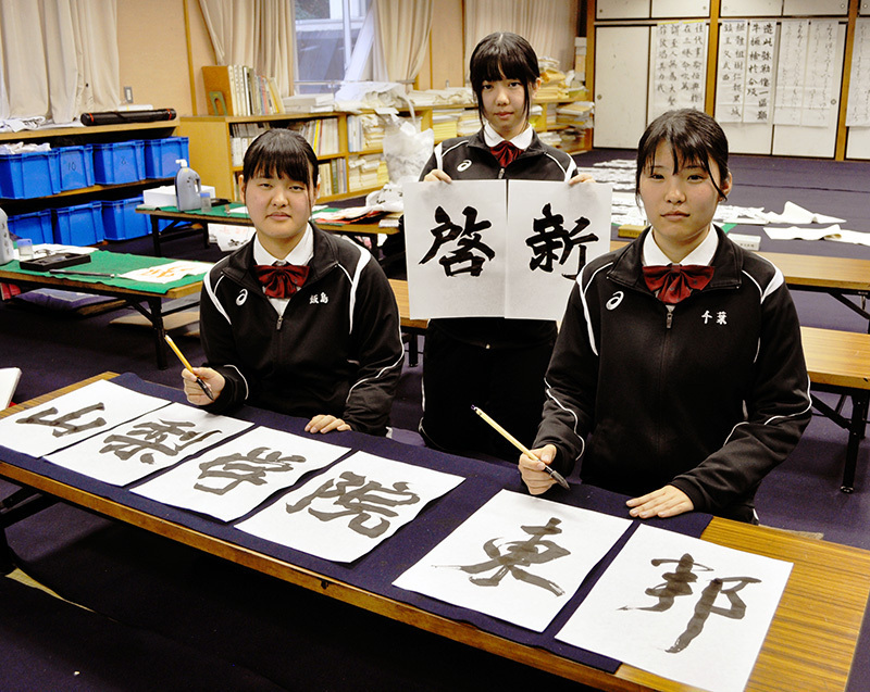 プラカードに校名を揮毫することになった浜松学芸高の（左から）飯島知咲さん、山下優月さん、千葉美由紀さん＝浜松市中区で、奥山智己撮影