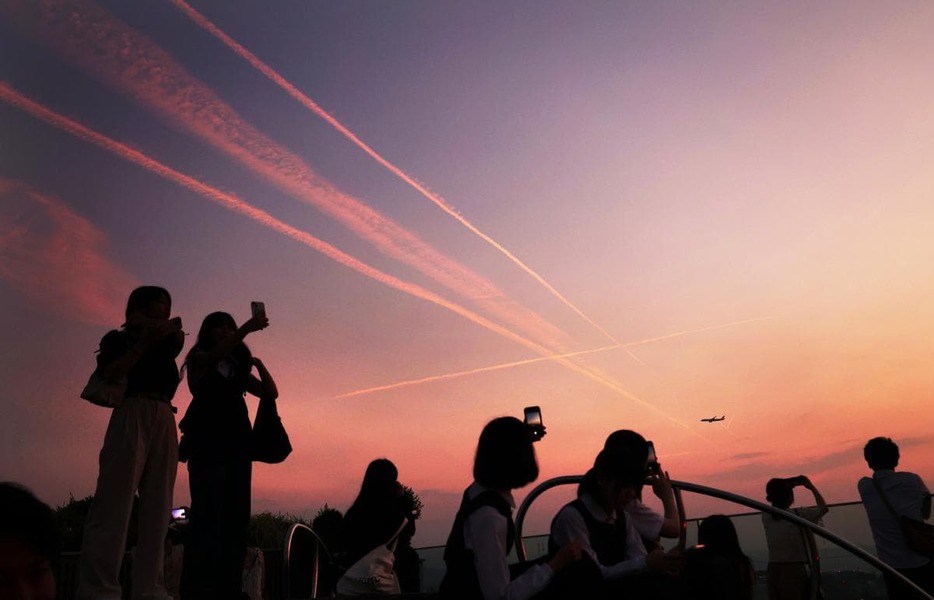 あかね色の空を横切る飛行機雲