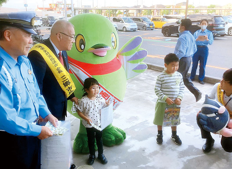 来店者に交通安全を呼びかける三郷市と吉川署の幹部ら＝24日、三郷市