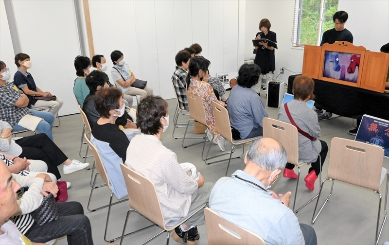 紙芝居で原発事故後の津島の様子を伝える岡さん（中央奥）ら