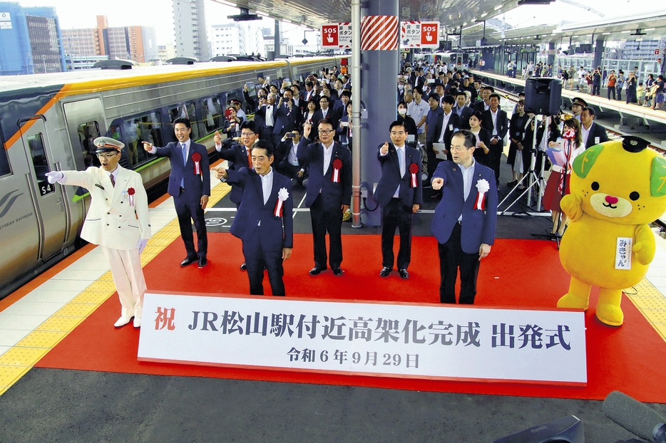 出発式で「出発進行」と合図を送る野本駅長（左）ら（松山市で）