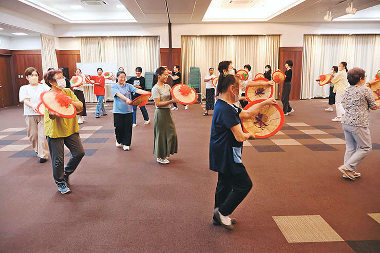 花がさを手に踊りを練習する参加者