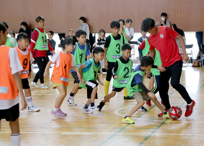 いわてグルージャ盛岡の選手（右）とサッカーを楽しむ児童