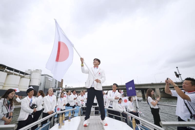 セーヌ川で行われたパリ五輪の開会式で、日の丸を手にする日本選手団旗手の半井重幸（中央）＝パリ（ゲッティ＝共同）