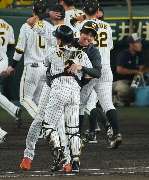 勝利後に抱き合って喜びを分かち合う才木（奥）と梅野＝甲子園球場（撮影・松永渉平)