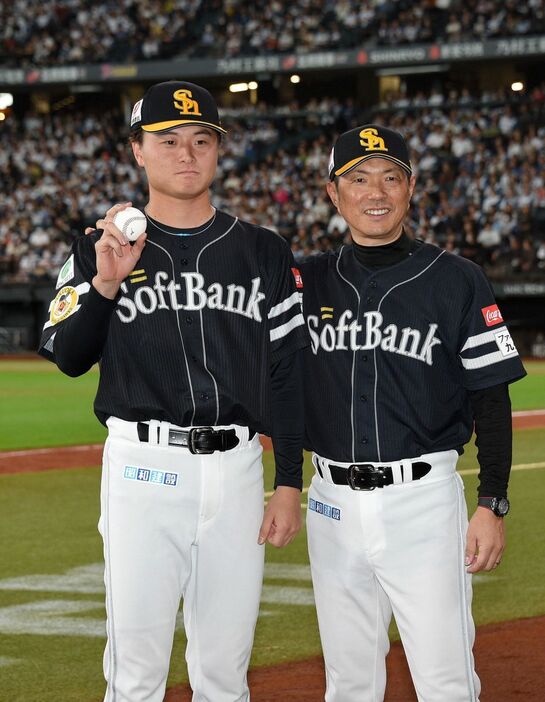 プロ初勝利を挙げ、ウイニングボールを手に小久保監督（右）と記念写真に納まる前田純（撮影・冨永豊）