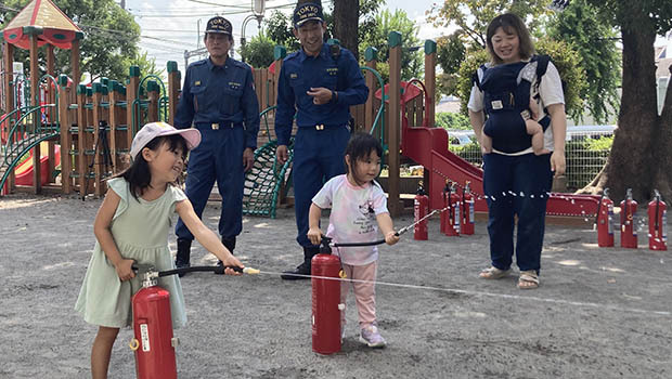 合同防災訓練で消火器体験をするこどもたち