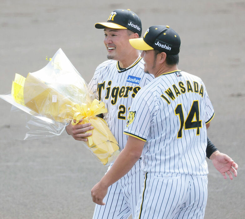 引退登板を終え、岩貞（右）から花束を贈られた秋山（カメラ・朝田　秀司）