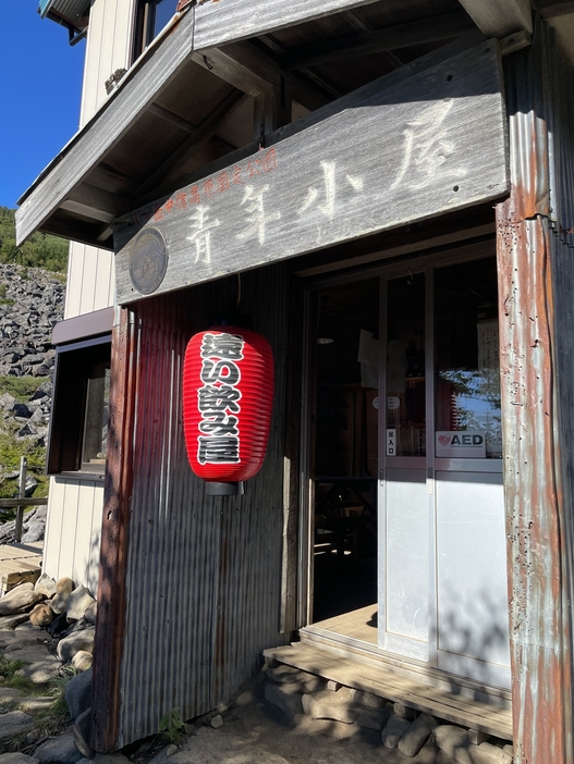 青年小屋の入り口。「遠い飲み屋」の提灯が登山客を迎える