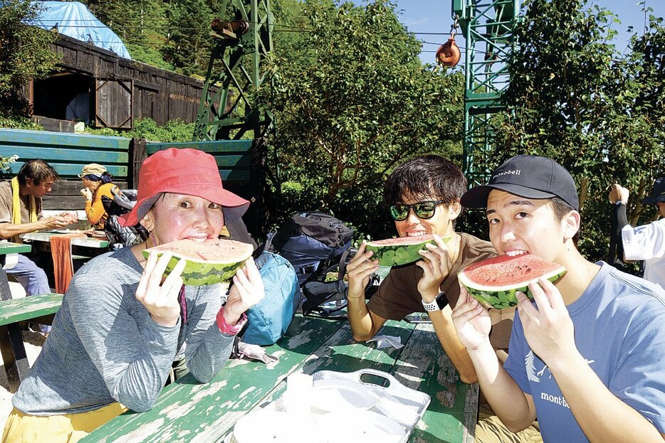 合戦小屋の夏の名物・スイカにかぶりつく登山者