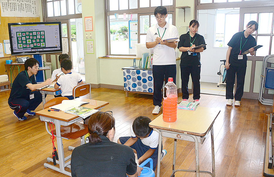 油井小中の複式学級の授業を見学する鹿大教育学部の学生たち＝4日、鹿児島県瀬戸内町油井