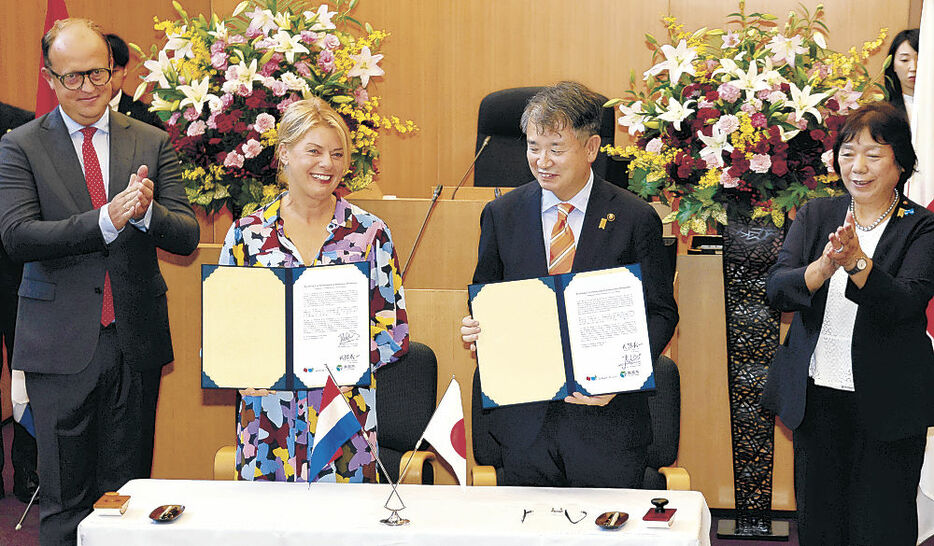 盟約書を交わすフリース市長（左から２人目）と武隈市長（同３人目）＝黒部市役所