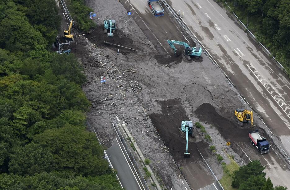 重機を使った撤去作業が続く、大分自動車道由布岳パーキングエリア付近の土砂崩れ現場＝1日午前11時29分、大分県由布市（共同通信社ヘリから）