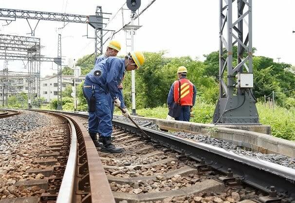 近鉄南大阪線の線路上で猛暑の中、保線作業をする係員＝７月１６日、大阪府羽曳野市