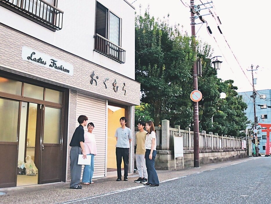 利活用する空き店舗の前で話す学生ら＝高岡市の高の宮通り