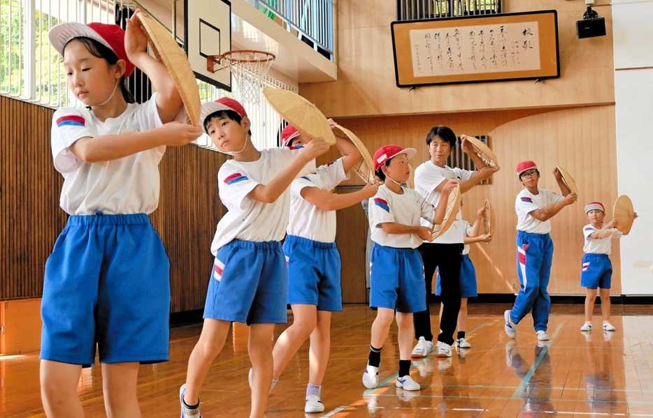 小学生にすげ笠音頭を教える竹内康人実行委員長（左から5人目）＝9月17日、福井県福井市の清水南小学校