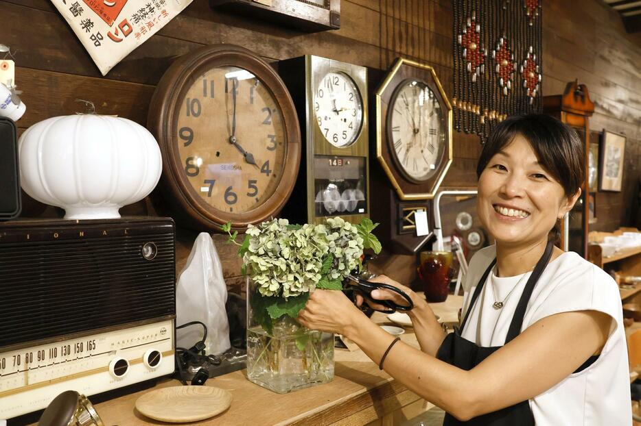 店内で笑顔を見せる「古道具とれじ」店主の加奈子さん＝7月、富山県滑川市