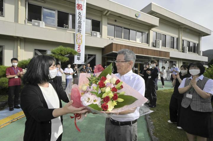 職員から花束を受け取る河野町長（右）