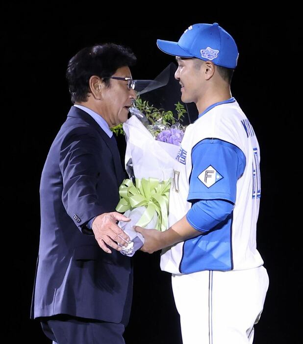 日本ハム・鍵谷陽平((右)へ花束を渡す日本ハム・栗山英樹CBO（撮影・三浦幸太郎）