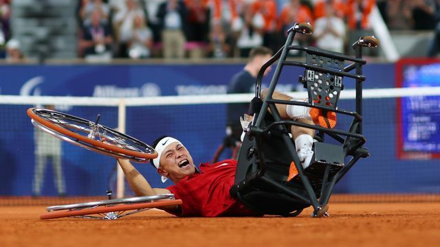 金メダルが決まり車輪を外し倒れ込む車いすテニスの小田凱人選手(写真：森田直樹/アフロスポーツ)