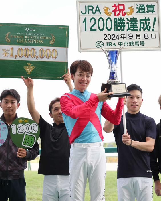 　ＪＲＡ通算１２００勝を達成し、２年連続でサマージョッキーズシリーズチャンピオンの表彰を受ける松山（中央）