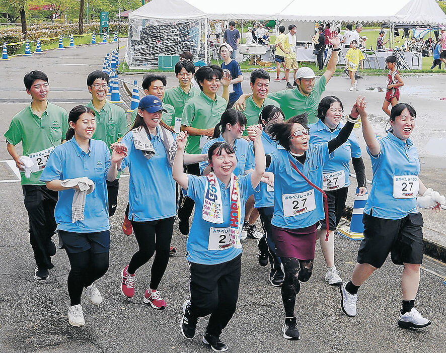 １１０周年の節目を喜び、走り抜ける石動信用金庫のメンバー＝８日、小矢部市のクロスランドおやべ