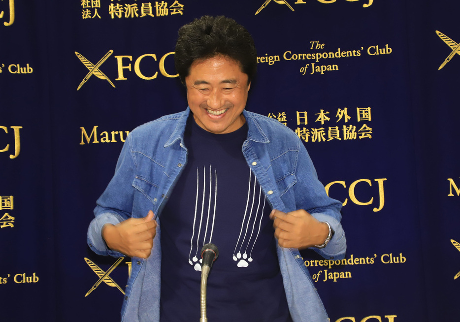 記者陣に猫のTシャツを見せる想田監督