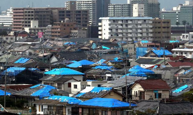 ブルーシートで覆われた住宅が点在する大淀川以南の住宅地。天候悪化の影響が懸念される＝９日午後、宮崎市